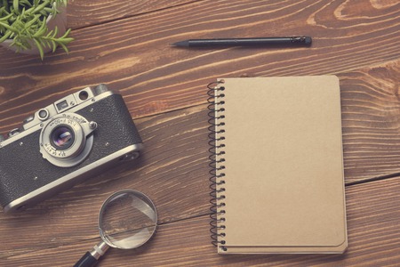 Travel,  vacation concept. Camera and supplies on office wooden desk table. Top view with copy space for text.の写真素材