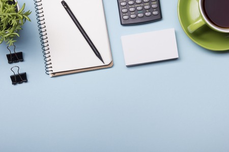 Office table with supply and coffe cup. View from above. Copy space for text.