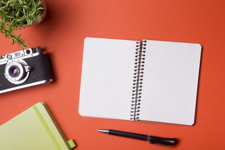 Tourism, travel concept. Office desk table with notepad, camera and supplies. Top view. Copy space for textの写真素材