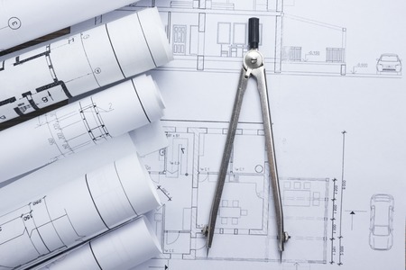 Architect worplace top view. Architectural project, blueprints, blueprint rolls and  divider compass on plans. Construction background. Engineering tools. Copy space.の写真素材