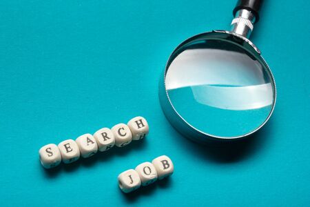 Job Search Concept. Magnifying glass and wooden block.の写真素材