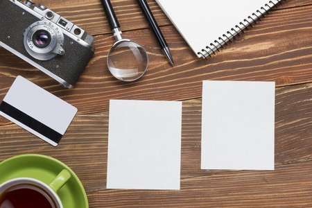 Travel, vacation concept. Camera, notepad, pen, credit card, supplies and photography on office wooden desk table. Top view with copy space for text.