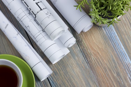 rchitect worplace top view. Architectural project, blueprints, blueprint rolls and  divider compass, calipers on vintage wooden desk table. Construction background. Engineering tools. Copy space.の写真素材