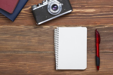 Travel,  vacation concept. Camera and supplies on office wooden desk table. Top view with copy space for text.の写真素材