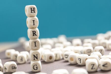 HIRING word written on wood block. Wooden Abc.