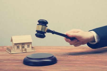 Auction, Real Estate concept. Hand with judge gavel and house model.の写真素材