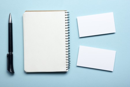 Business card blank over notepad at office table. Corporate stationery branding mock-up.の写真素材