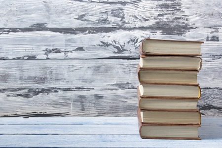 Stack of hardback books on wooden table. Back to school. Copy space for text.の写真素材