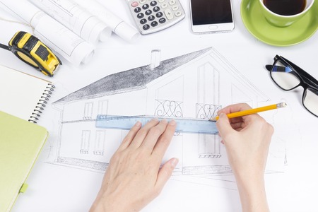 Architect working on blueprint. Architects workplace - architectural project, blueprints, ruler, calculator, laptop and divider compass. Construction concept. Engineering tools. Top viewの写真素材