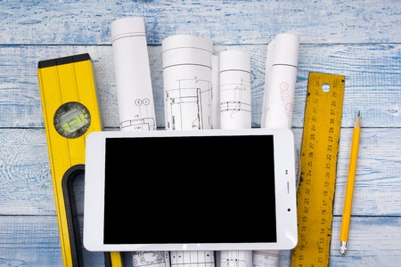 Architect worplace top view. Architectural project, blueprints, blueprint rolls on wooden desk...