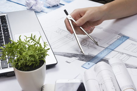 Architect working on blueprint. Architects workplace - architectural project, blueprints, ruler, calculator, laptop and divider compass. Construction concept. Engineering tools. Top viewの写真素材