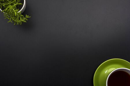 Dark Office desk table with coffee cup and flower. Top view. Copy space for text.の写真素材