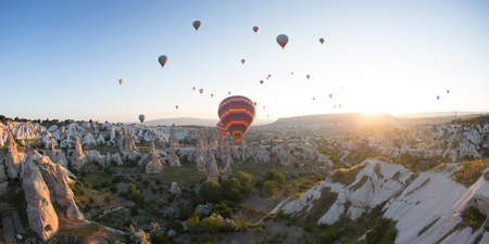 Hot air balloons over mountain landscapeの写真素材