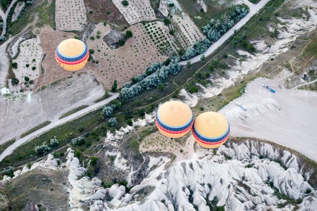 Hot air balloons over mountain landscape in Cappadocia, Goreme National Park, Turkey.の写真素材