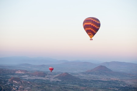 Hot air balloons over mountain landscape in Cappadocia, Goreme National Park, Turkey.の写真素材