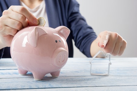 Hand putting coin into piggy bank closeup. selective focusの写真素材