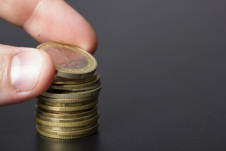Money, Financial, Business Growth concept, Savings, close up of female hand stacking golden coins