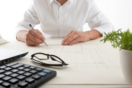 Architects working on blueprint. Architects workplace - architectural project, blueprints, ruler, calculator, laptop and divider compass. Construction concept. Engineering tools.の写真素材