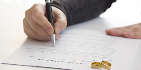 Hands of wife, husband signing decree of divorce, dissolution, canceling marriage, legal separation documents, filing divorce papers or premarital agreement prepared by lawyer. Wedding ring.の写真素材