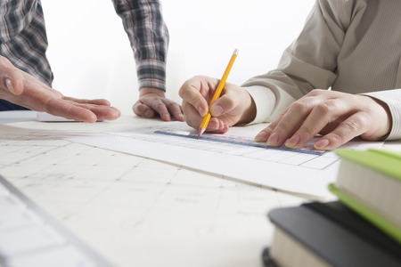 Architects working on blueprint, real estate project. Architect workplace - architectural project, blueprints, ruler, calculator, laptop and divider compass. Construction concept. Engineering tools.の写真素材