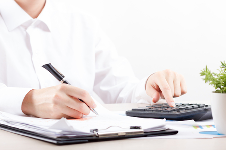 Close up of female accountant or banker making calculations. Savings, finances and economy conceptの写真素材