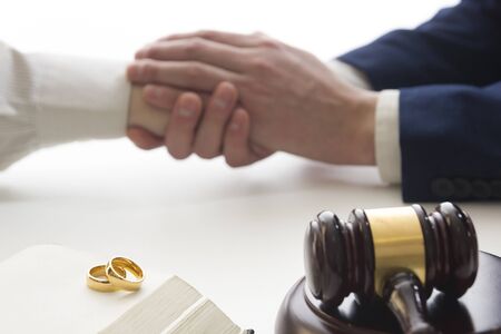 Divorce concept. Hands of wife, husband signing decree of divorce, canceling marriage, legal separation documents.の写真素材