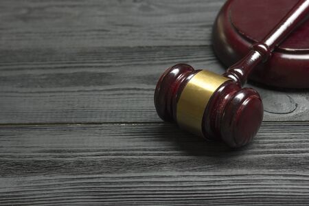 Law concept - Open law book with a wooden judges gavel on table in a courtroom or law enforcement officeの写真素材