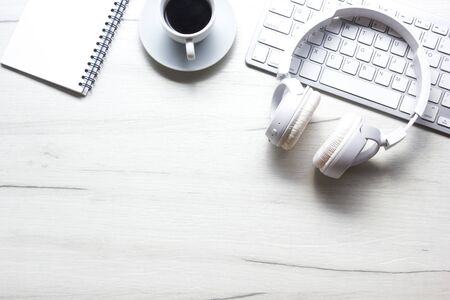 White desk office with laptop, smartphone and other work supplies with cup of coffee. Top view with...