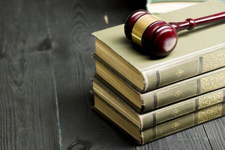 Law concept - Open law book with a wooden judges gavel on table in a courtroom or law enforcement office isolated on white background. Copy space for text.の写真素材