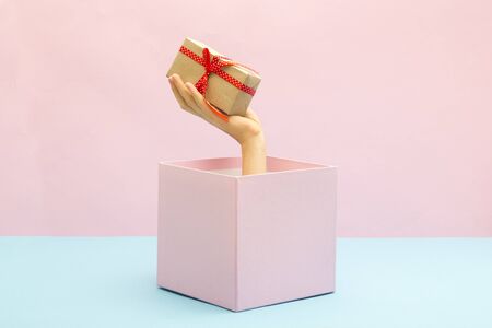 Woman holding a gift box in a gesture of giving. Special offer or sale concept. Christmas.の写真素材