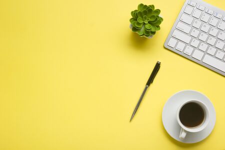 Yellow desk office with laptop, smartphone and other work supplies with cup of coffee. Top view with copy space for input the text. Designer workspace on desk table essential elements on flat layの写真素材