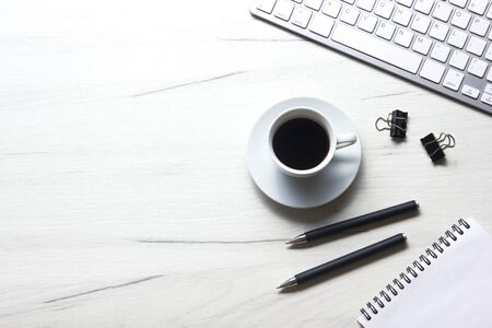 White desk office with laptop, smartphone and other work supplies with cup of coffee. Top view with...