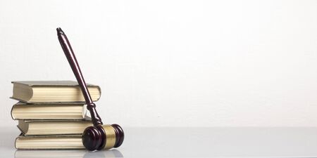 Law concept - Open law book with a wooden judges gavel on table in a courtroom or law enforcement office isolated on white background. Copy space for textの写真素材