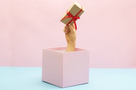 Woman holding a gift box in a gesture of giving. Special offer or sale concept. Christmasの写真素材