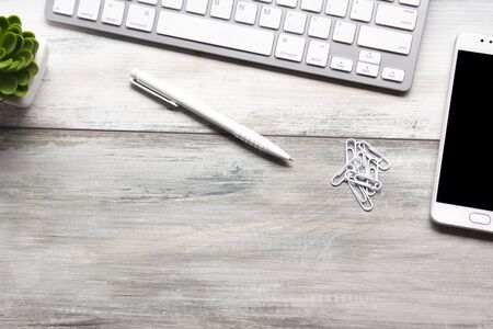 White desk office with laptop, smartphone and other work supplies with cup of coffee. Top view with...