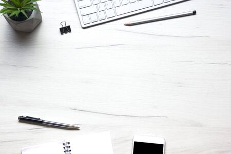 White desk office with laptop, smartphone and other work supplies with cup of coffee. Top view with...