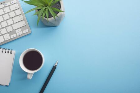 Blue desk office with laptop, smartphone and other work supplies with cup of coffee. Top view with copy space for input the text. Designer workspace on desk table essential elements on flat lay.の写真素材