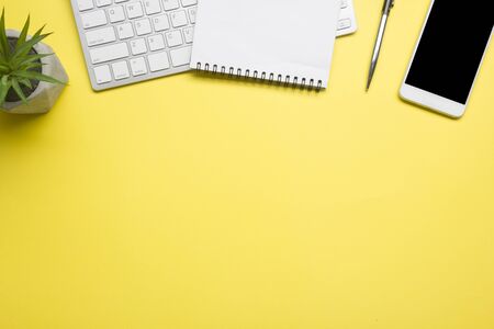 Yellow desk office with laptop, smartphone and other work supplies with cup of coffee. Top view with copy space for input the text. Designer workspace on desk table essential elements on flat lay.の写真素材