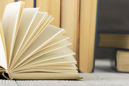 Open book, hardback books on wooden table. Back to school. Copy space.