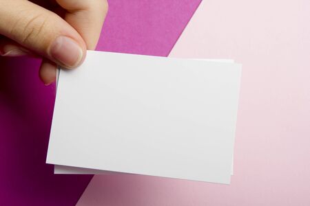 Hand holding white business card on abstract backgroundの写真素材