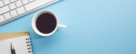Blue desk office with laptop, smartphone and other work supplies with cup of coffee. Top view with copy space for input the text. Designer workspace on desk table essential elements on flat lay.の写真素材