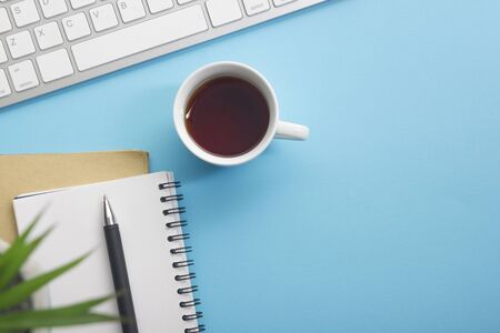 Blue desk office with laptop, smartphone and other work supplies with cup of coffee. Top view with copy space for input the text. Designer workspace on desk table essential elements on flat lay.の写真素材