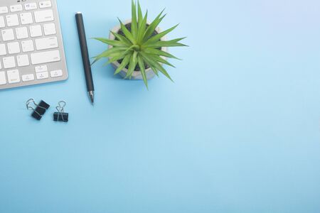 Blue desk office with laptop, smartphone and other work supplies with cup of coffee. Top view with copy space for input the text. Designer workspace on desk table essential elements on flat layの写真素材