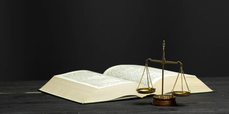 Law concept - Open law book with a wooden judges gavel on table in a courtroom or law enforcement office isolated on white background. Copy space for text.の写真素材