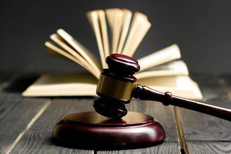 Law concept - Open law book with a wooden judges gavel on table in a courtroom or law enforcement office isolated on white background. Copy space for text