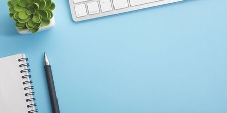 Blue desk office with laptop, smartphone and other work supplies with cup of coffee. Top view with copy space for input the text. Designer workspace on desk table essential elements on flat lay.の写真素材