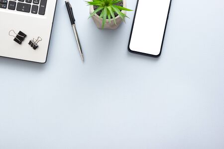 Blue desk office with laptop, smartphone and other work supplies with cup of coffee. Top view with copy space for input the text. Designer workspace on desk table essential elements on flat lay.の写真素材