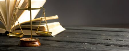 Law concept - Open law book with a wooden judges gavel on table in a courtroom or law enforcement office isolated on white background. Copy space for textの写真素材