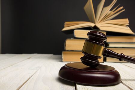Law concept - Open law book with a wooden judges gavel on table in a courtroom or law enforcement office isolated on white background. Copy space for textの写真素材