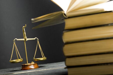 Law concept - Open law book with a wooden judges gavel on table in a courtroom or law enforcement office isolated on white background. Copy space for textの写真素材